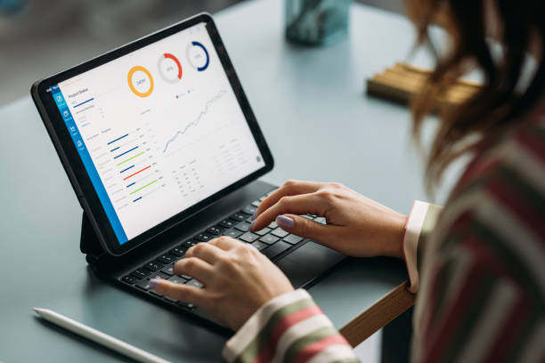 femme professionnelle analysant des données sur une tablette au bureau de travail - augmenter ses performance commerciales photos et images de collection