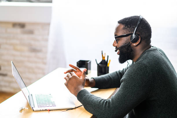 homme afro-américain avec le casque utilisant l’ordinateur portatif - formation vente photos et images de collection